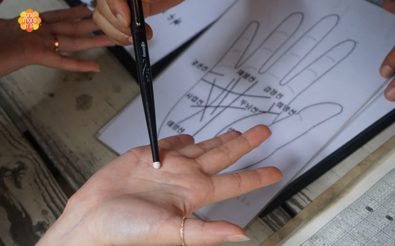 Korean fortune teller pointing at palm